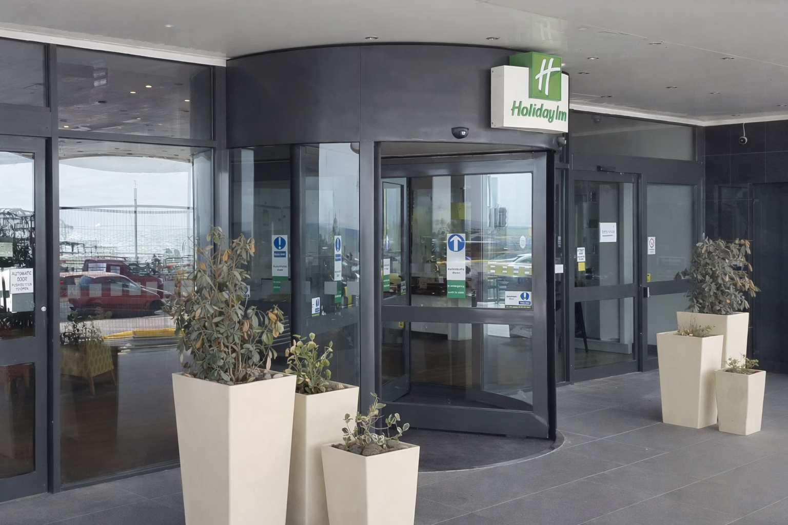 Holiday Inn revolving glass entrance with planters